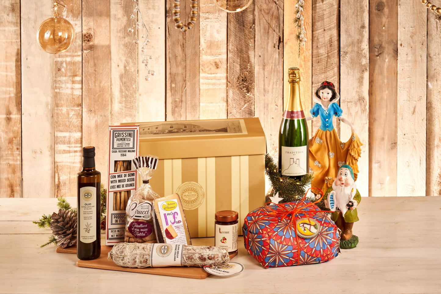 Cesto natalizio Biancaneve e i sette nani. All'interno contiene: panettone al cioccolato 1 Kg, salame gentile Maletti 700 g, grissini piemontesi ai semi 150 g, composta di fragole 210 g, formaggio affinato al vino rosso 300 g, olio extra vergine di oliva Maletti 500 ml, ciambelline al vino rosso 250 g, Blanquette de Limoux tradition Antech 75 cl.
