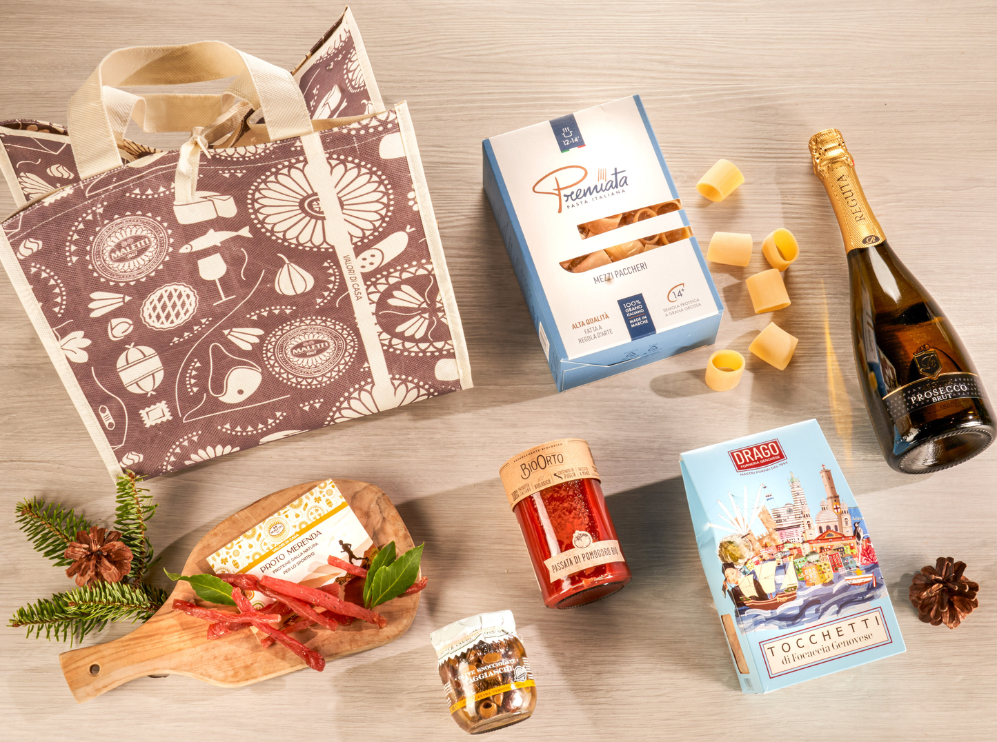 Cesta natalizia enogastronomica "Il Natale dello Sportivo" con pasta artigianale, passata bio, carne secca di tacchino, focaccia genovese, olive taggiasche e Prosecco DOC, confezionata in shopper natalizia elegante.