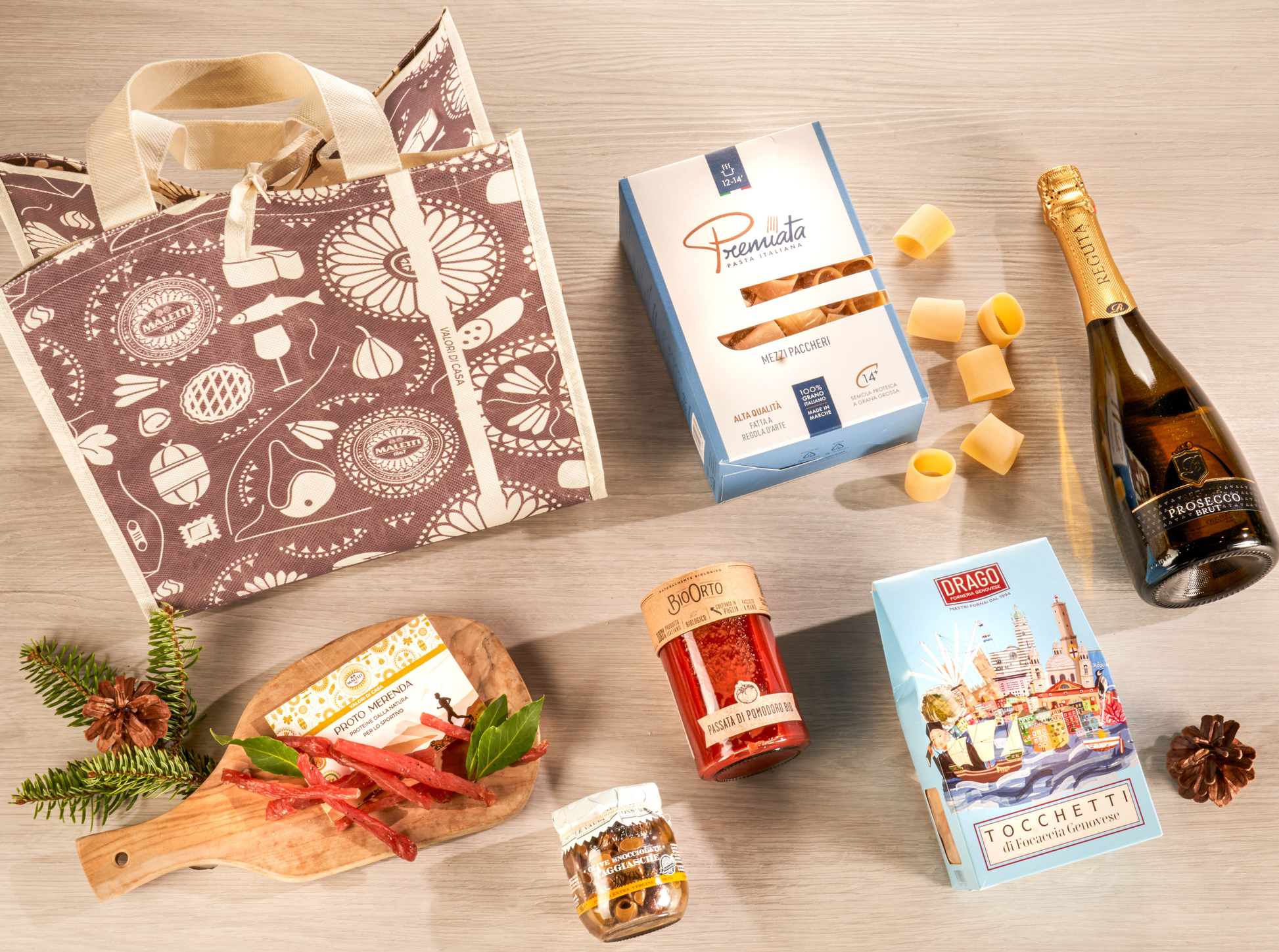 Cesta natalizia enogastronomica "Il Natale dello Sportivo" con pasta artigianale, passata bio, carne secca di tacchino, focaccia genovese, olive taggiasche e Prosecco DOC, confezionata in shopper natalizia elegante.