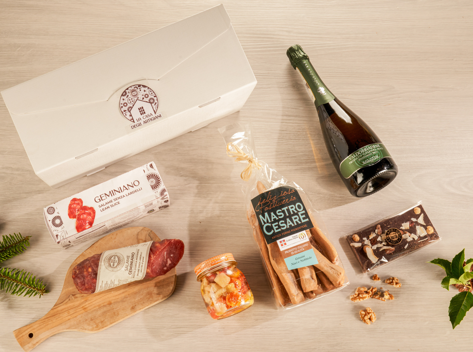 Cesta natalizia enogastronomica "TÊTE-À-TÊTE di Natale" con Prosecco Valdobbiadene, salame artigianale, giardiniera, grissini al Nebbiolo, cioccolato fondente, frutta secca e cofanetto regalo elegante.