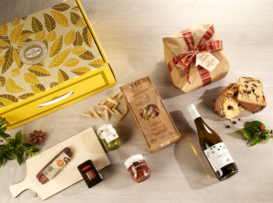 Cesta natalizia enogastronomica "Un Natale Gourmet al Mare" con panettone al cioccolato, bottarga di muggine, tonno rosso siciliano, pesto senza aglio, vino Pecorino IGT, pasta artigianale e valigetta regalo elegante.
