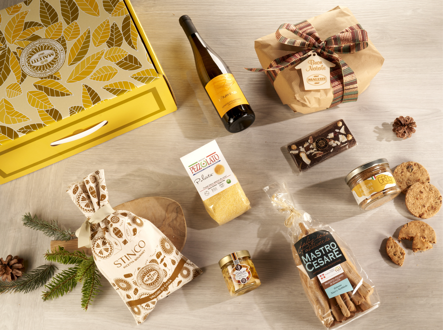 Cesta natalizia enogastronomica "Un Natale Gourmet in Montagna" con stinco, polenta, funghi porcini, panettone, Gewürztraminer e biscotti, confezionata in valigetta elegante.